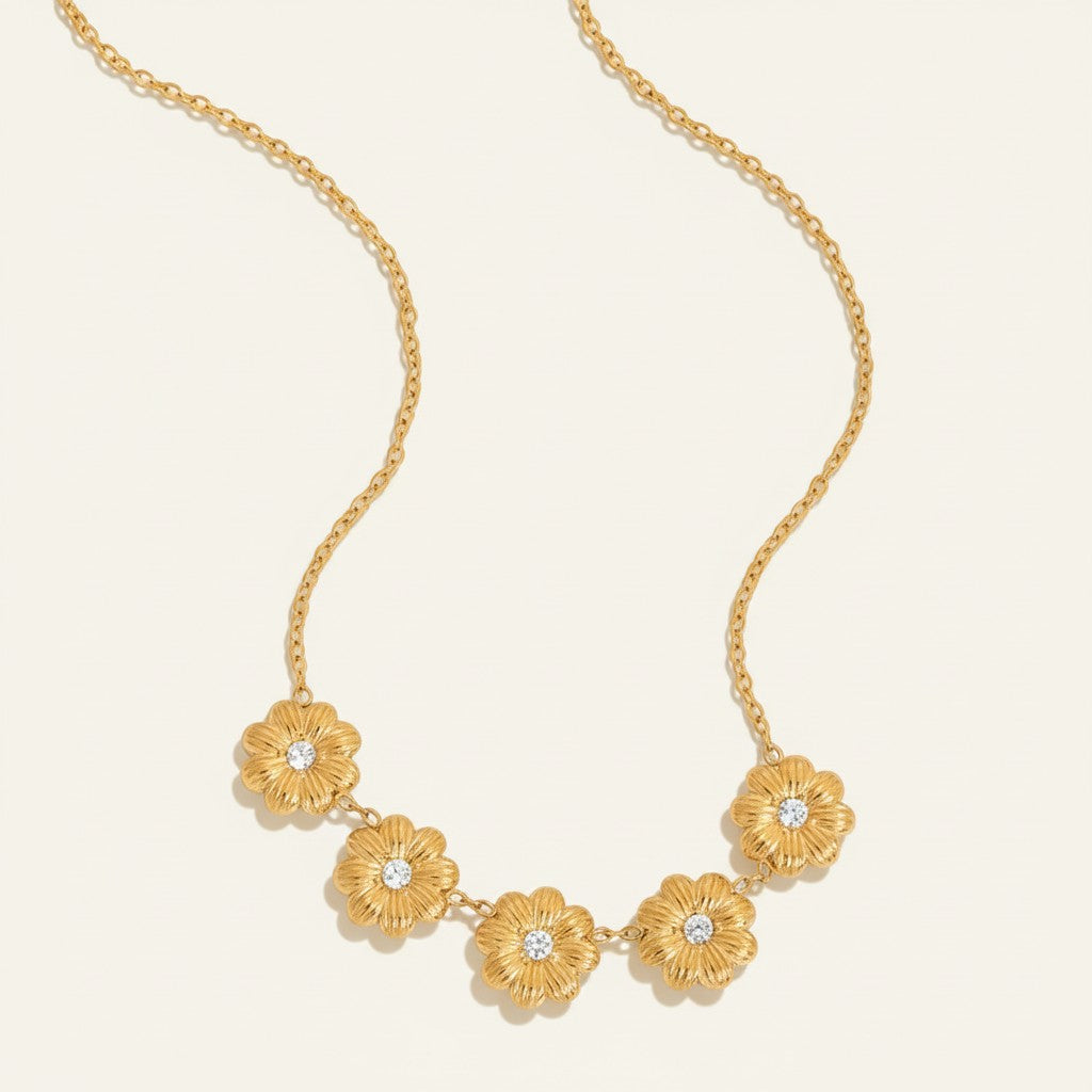 Seraphina Treasures gold necklace with five textured floral pendants, each with a clear crystal center.