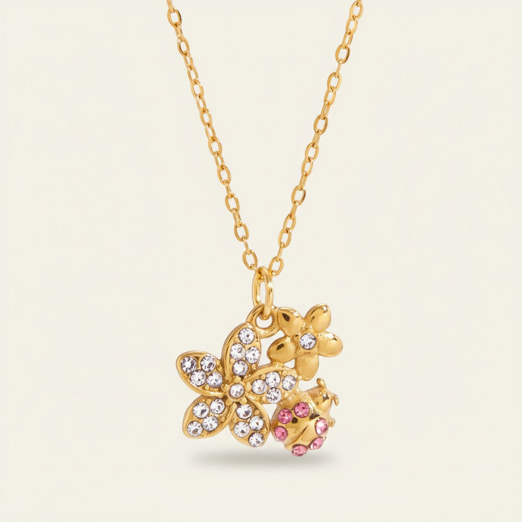 Seraphina Treasures gold necklace with crystal-embellished flowers and a pink ladybug charm.