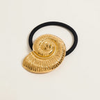 Seraphina Treasures gold fossil shell hair tie with black elastic band.