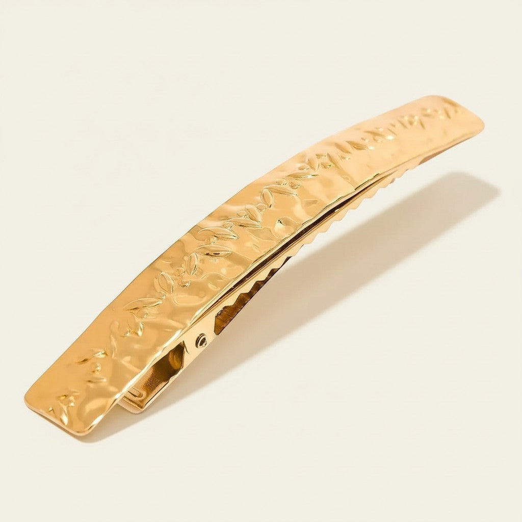 Seraphina Treasures gold metal hair clip with hammered texture and embossed floral pattern.