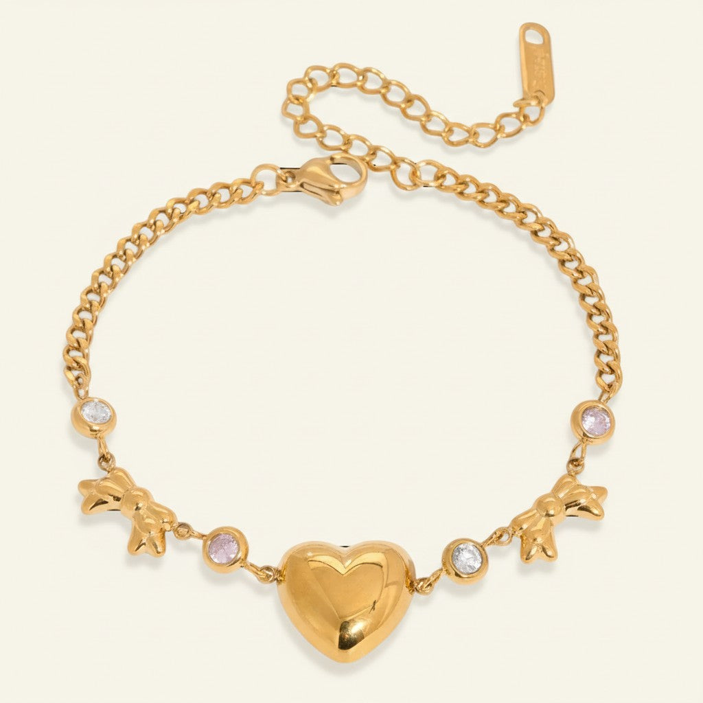 Seraphina Treasures gold-tone bracelet with heart and bowknot charms, accented with clear and pink crystals.