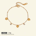 Seraphina Treasures gold-tone bracelet with delicate chain, featuring five heart charms and three sparkling zirconia stones. Adjustable length.