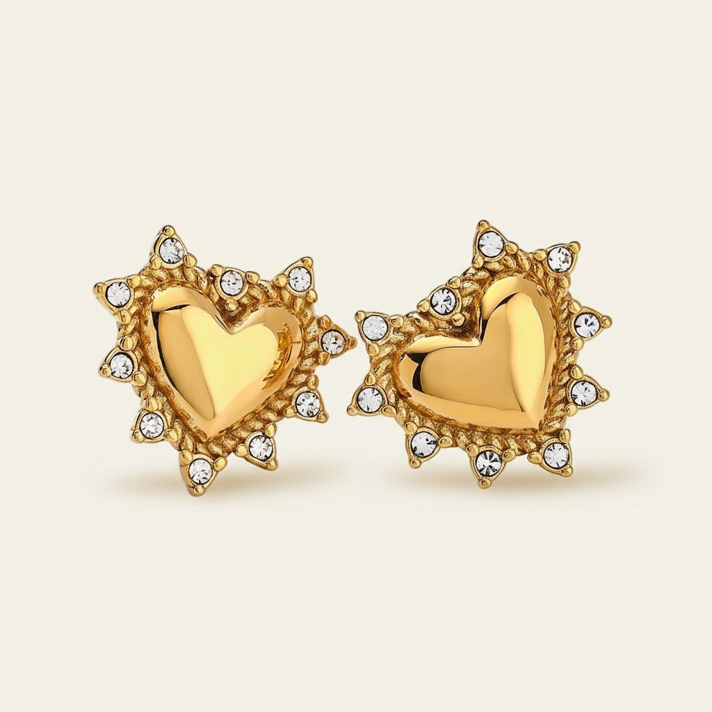 Seraphina Treasures gold heart stud earrings with clear crystal accents and a sunburst-like border.