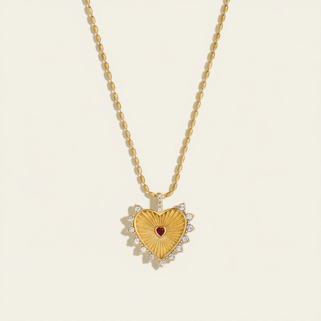 Seraphina Treasures gold heart necklace with red center stone and clear zirconia accents.