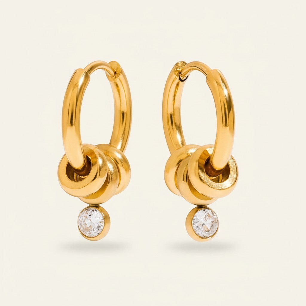 Seraphina Treasures gold hoop earrings with white zirconia stones and stacked ring detail.