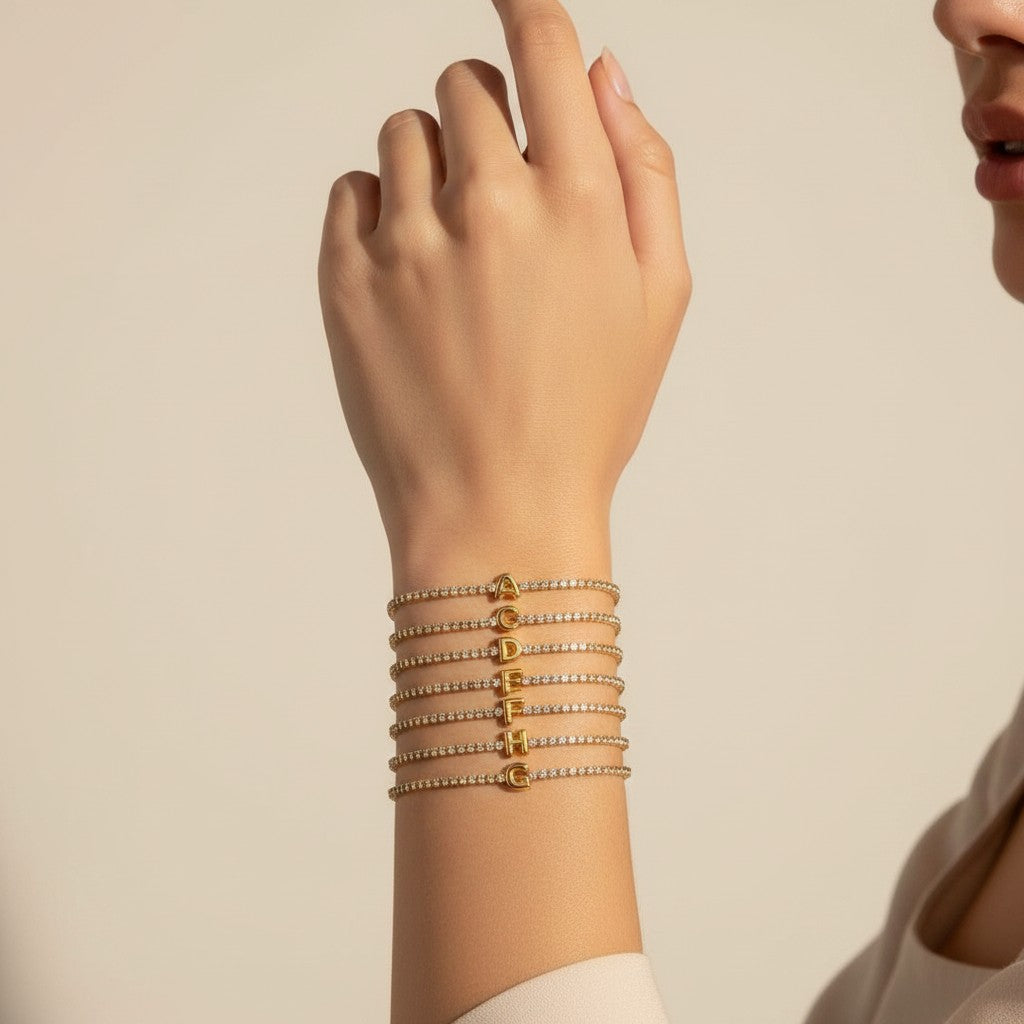 Seraphina Treasures gold tennis bracelet with clear cubic zirconia and a gold initial pendant, shown in letters A through J.