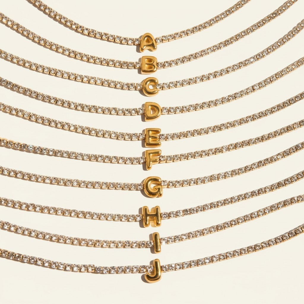 Seraphina Treasures gold tennis bracelet with clear zirconia stones and a gold initial pendant.