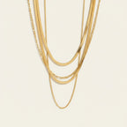 Seraphina Treasures gold layered necklace with Figaro and herringbone chains. Elegant and versatile.