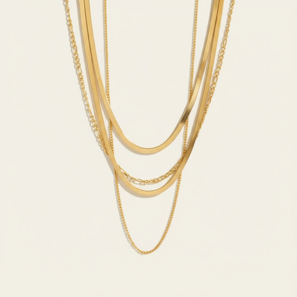 Seraphina Treasures gold layered necklace with Figaro and herringbone chains. Elegant and versatile.