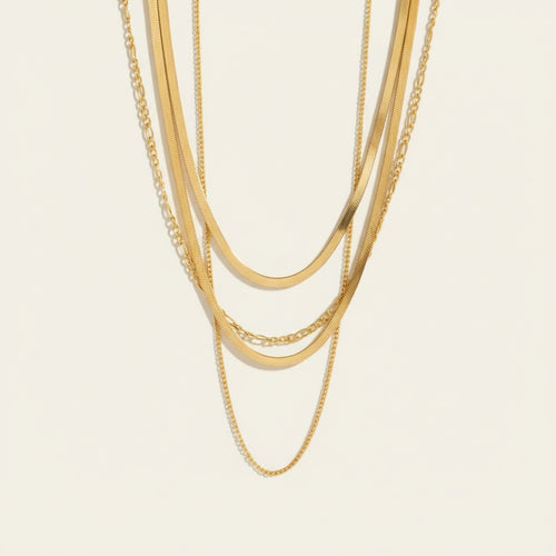 Seraphina Treasures gold layered necklace with Figaro and herringbone chains. Elegant and versatile.