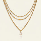 Seraphina Treasures gold layered necklace with a pear-cut white zircon pendant. Delicate chains with bead and flat link accents.