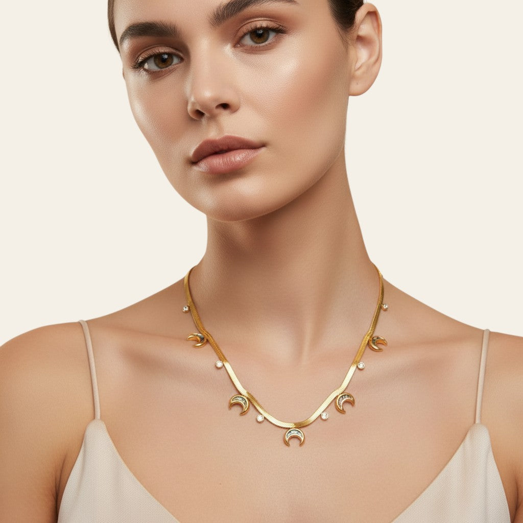 Seraphina Treasures gold serpentine chain necklace with scattered moon and round crystal pendants.