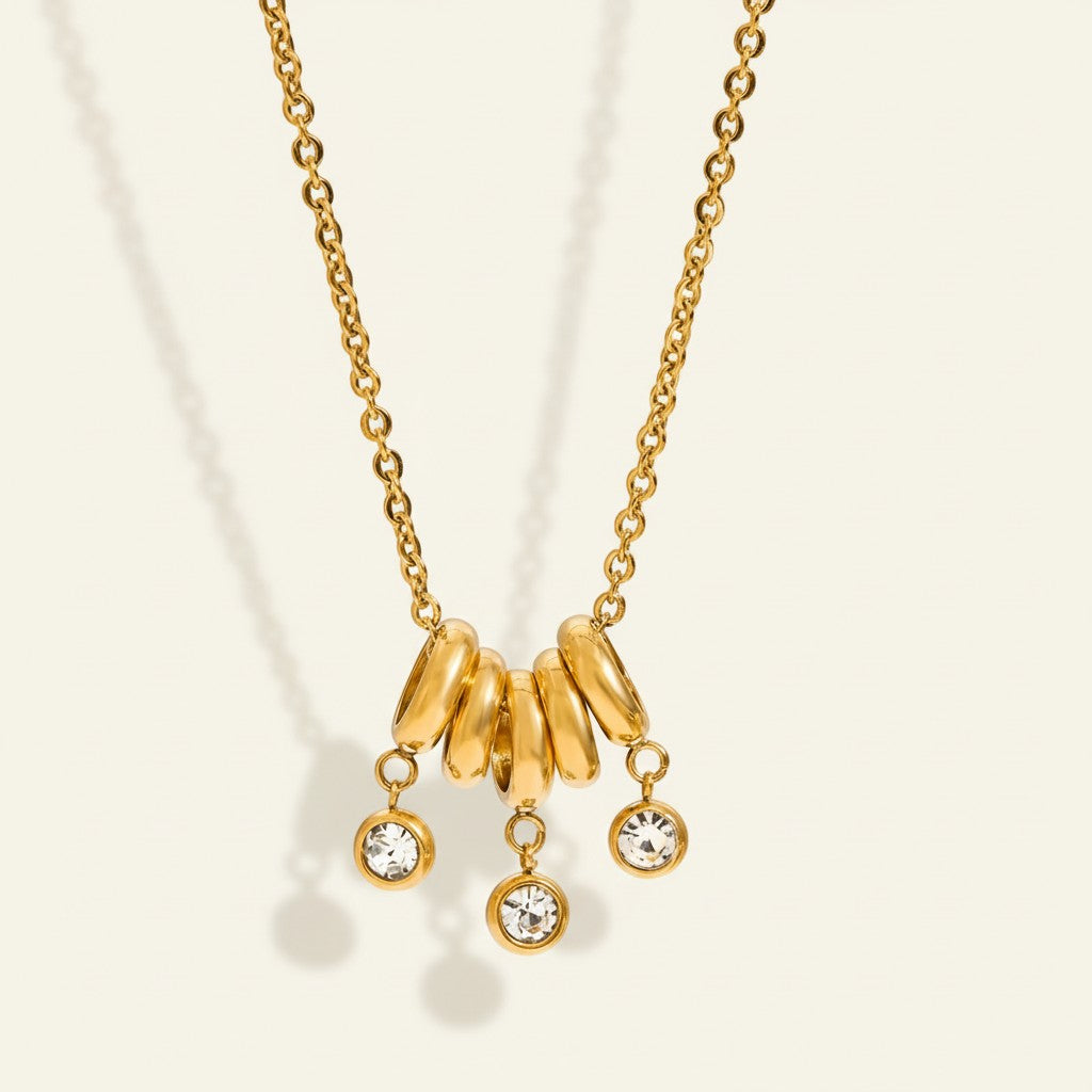 Seraphina Treasures gold necklace with five rings and three dangling rhinestones. Elegant chain necklace.