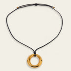 Seraphina Treasures gold-tone ring pendant necklace on black wax cord with adjustable tie closure.