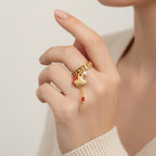 Seraphina Treasures gold ring with shell, coral, pearl, and bead charms. Adjustable chain link band.
