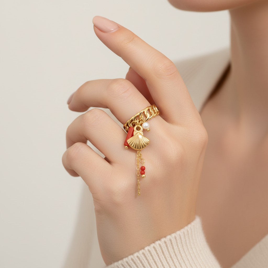 Seraphina Treasures gold ring with shell, coral, pearl, and bead charms. Adjustable chain link band.