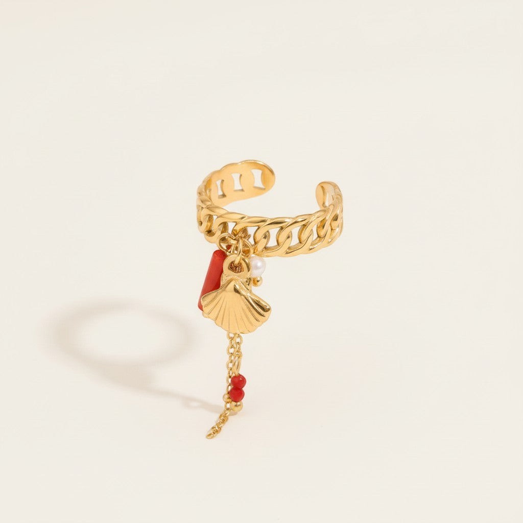 Seraphina Treasures gold ring with shell charm, coral accent, and pearl. Chain with red beads dangles.