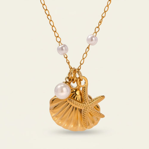 Seraphina Treasures gold necklace with pearl beads, a shell, and a starfish charm. Coastal elegance.
