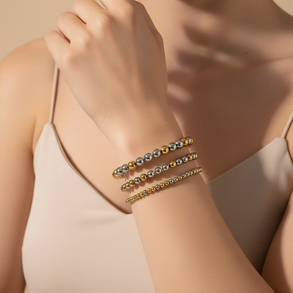 Seraphina Treasures Clio bracelet with alternating gold and silver stainless steel beads. Elastic design for a comfortable fit.