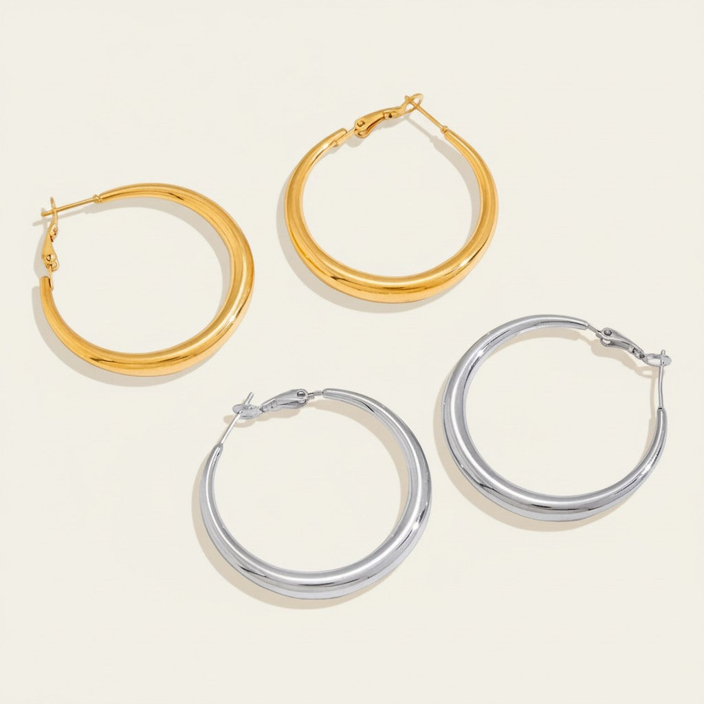 Seraphina Treasures Kyphera gold and silver polished hoop earrings. Smooth, curved silhouette.