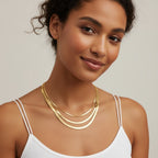 Seraphina Treasures Iridelle layered gold snake chain necklaces on a woman's neck.