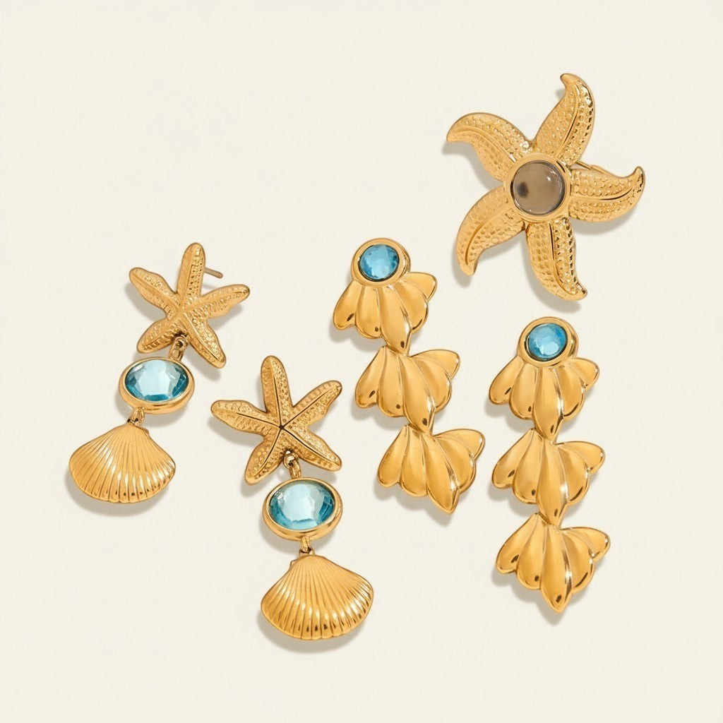 Seraphina Treasures gold starfish and shell earrings with blue gems. Nautical-themed dangle earrings.