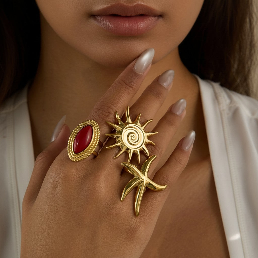 Seraphina Treasures gold-tone adjustable rings featuring a red oval stone, a sunburst, and a starfish design.
