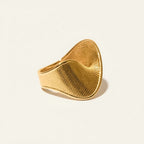 Seraphina Treasures gold-tone metal ring with a twisted, textured geometric design. Modern statement jewelry.