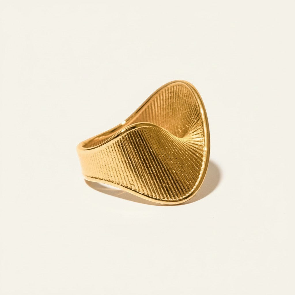Seraphina Treasures gold-tone metal ring with a twisted, textured geometric design. Modern statement jewelry.