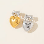 Seraphina Treasures Zaleira gold and silver heart earrings with bowknot detail.