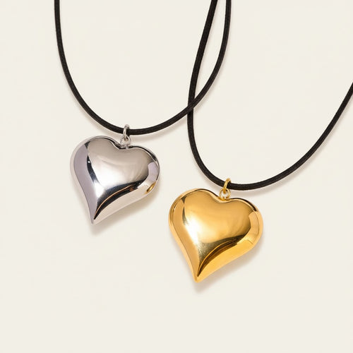 Seraphina Treasures Amunet necklace with a polished silver and gold heart pendant on black cords.