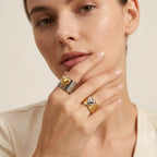 Seraphina Treasures Orvara ring with a gold heart accent on a silver band, and a silver heart accent on a gold band.