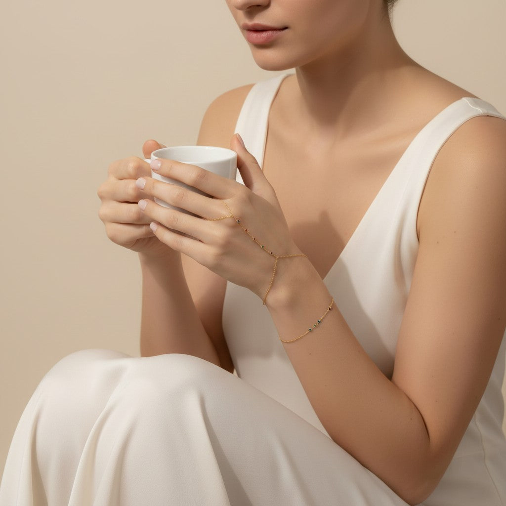 Seraphina Treasures Hecate bracelet with colorful zircon accents on a gold chain, connecting the wrist to the finger.