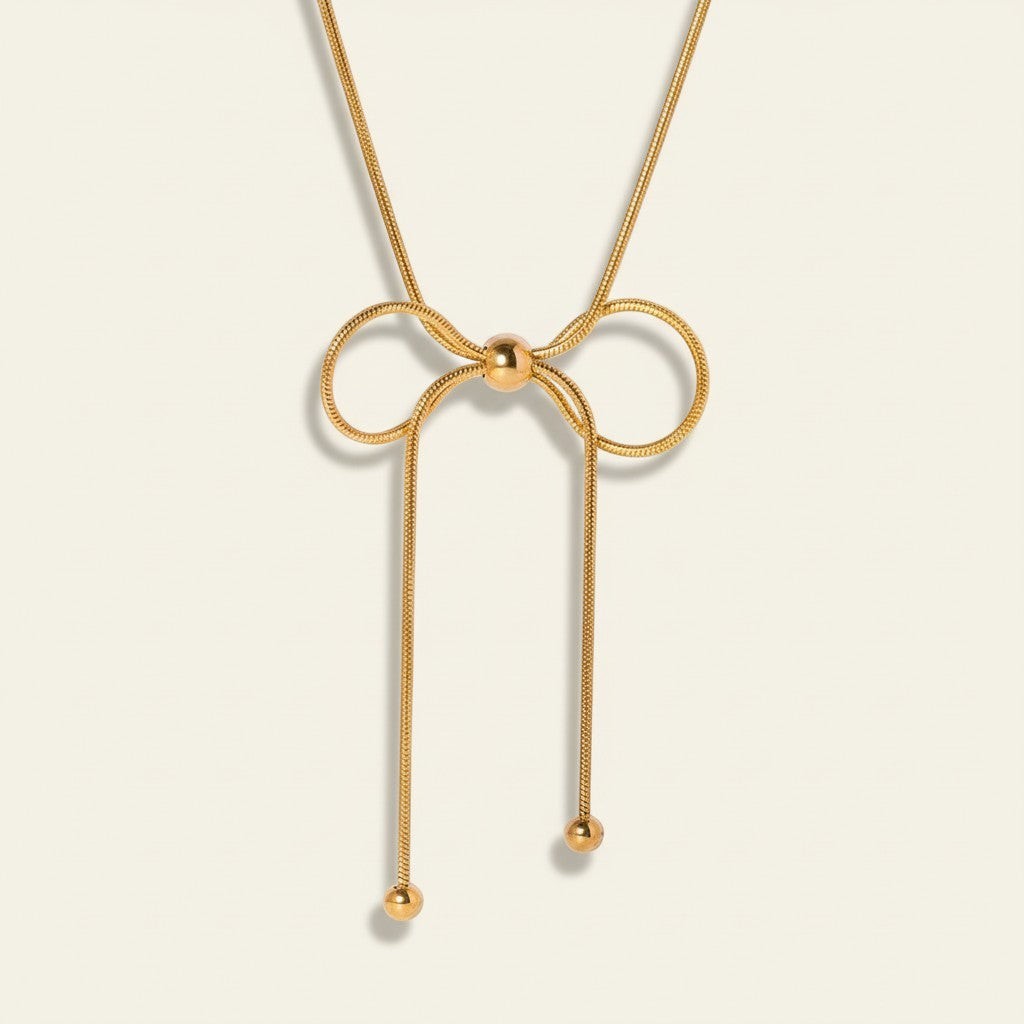 Seraphina Treasures Isara gold bow necklace with adjustable length and ball ends. Elegant and versatile.