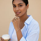 Seraphina Treasures Junia bracelet with white zirconia stones and gold band, worn on a hand with rings.
