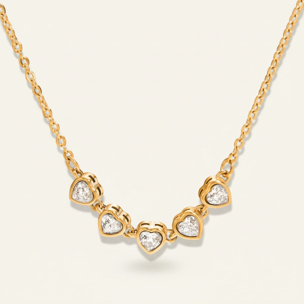 Seraphina Treasures Keturah necklace with five sparkling cubic zirconia hearts on a gold chain.