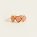 Seraphina Treasures Koralyne ring with three pink heart-shaped stones set in gold-tone metal.