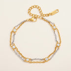 Seraphina Treasures Kymara bracelet with dual gold and silver chains adorned with round zircons. Elegant mixed metal design.