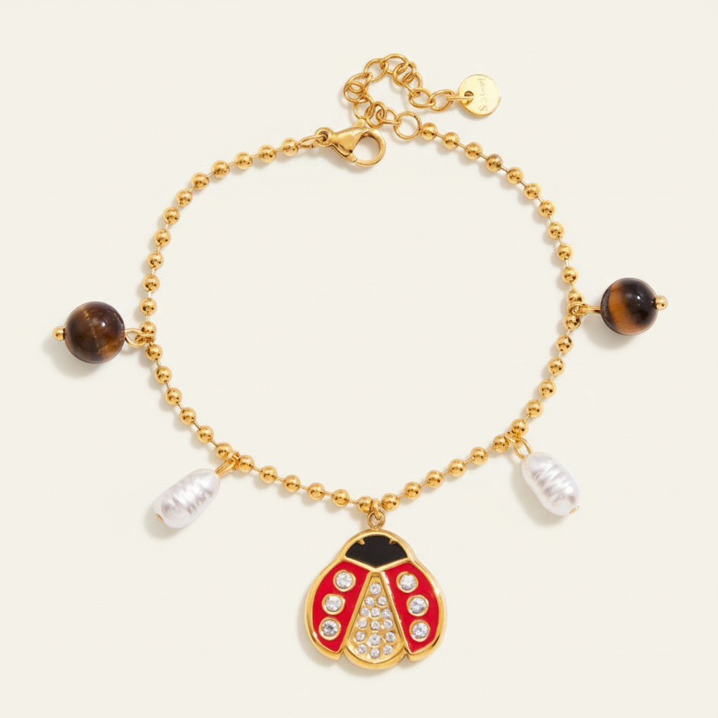 Seraphina Treasures gold beaded bracelet with ladybug charm, pearls, and tiger eye beads.