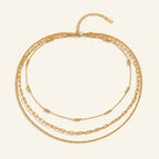 Seraphina Treasures Eileithyia layered gold necklace with mixed chain styles and bead accents.