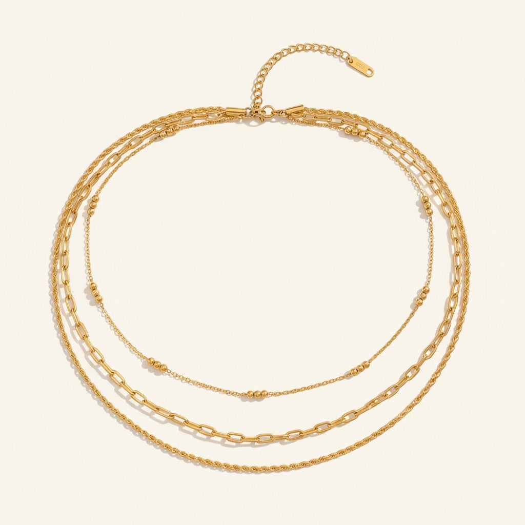 Seraphina Treasures Eileithyia layered gold necklace with mixed chain styles and bead accents.
