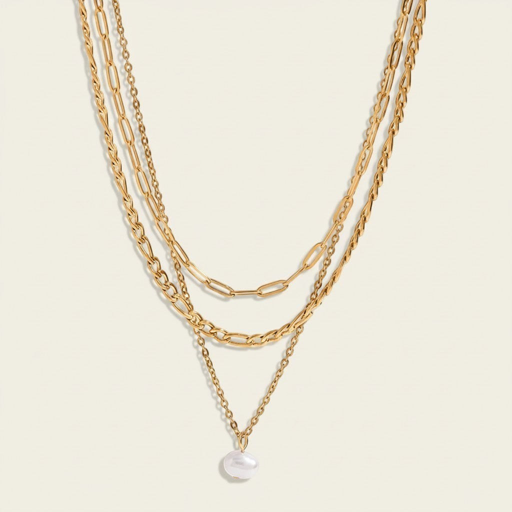 Seraphina Treasures Yasira layered gold necklace with a single pearl pendant. Features multiple chain styles.