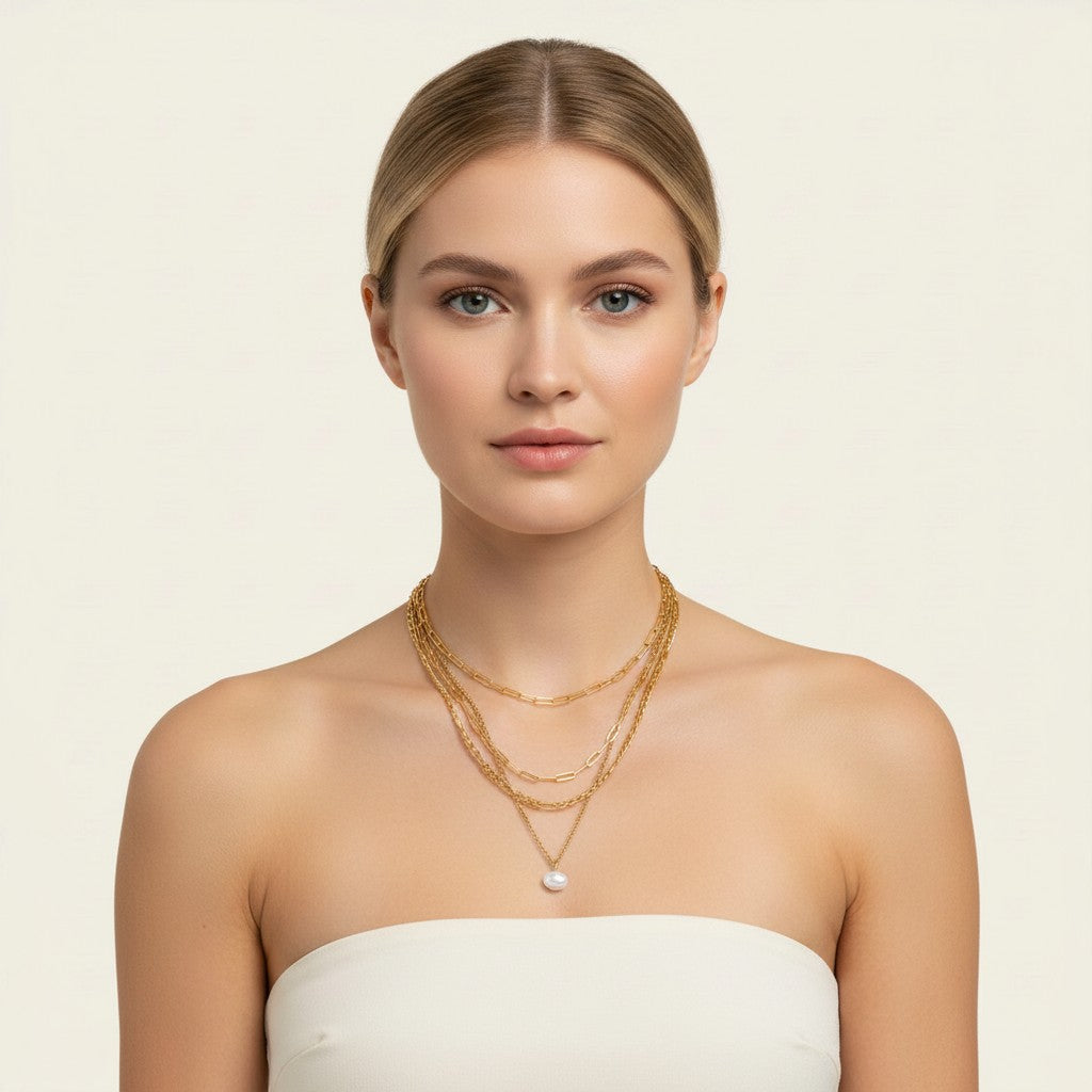 Seraphina Treasures Yasira layered gold necklace with a single pearl pendant. Features delicate chains of varying styles.