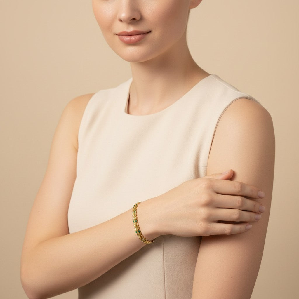 Seraphina Treasures Livia bracelet with gold olive leaf design and green accents on a woman's wrist.