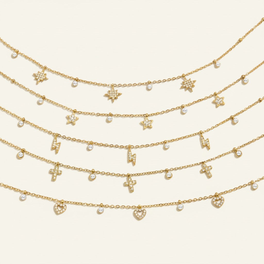 Seraphina Treasures Marcellina gold necklaces with crystal star, lightning bolt, cross, and heart charms.