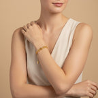 Seraphina Treasures Medea gold tone bracelet with shell charms on a woman's wrist.