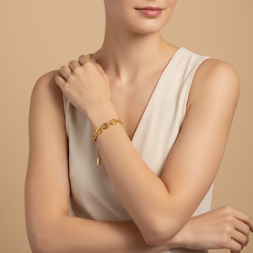 Seraphina Treasures Medea gold tone bracelet with shell charms on a woman's wrist.
