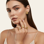 Seraphina Treasures Moirai gold rings with sun and moon motifs, one featuring a pink stone. Celestial-inspired.