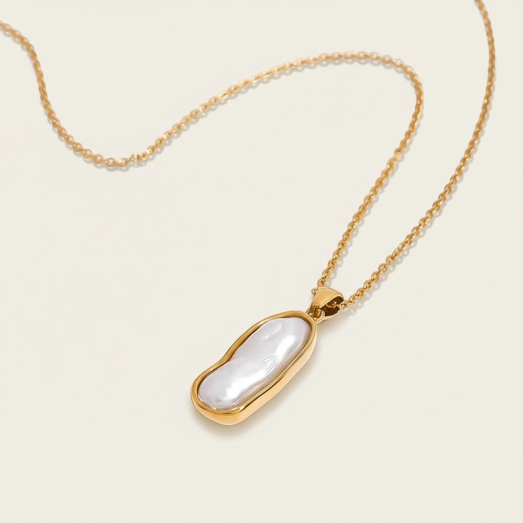 Seraphina Treasures Nerys necklace with a gold chain and an irregular white pearl pendant in a gold bezel setting.