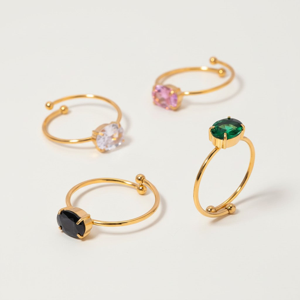 Seraphina Treasures Noctilya adjustable rings in gold with clear, pink, green, and black oval stones.